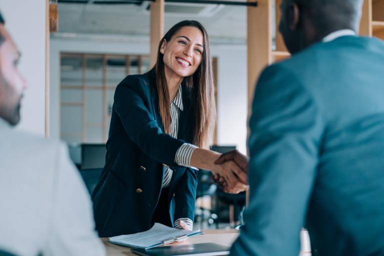 Staff shaking hands during a meeting
